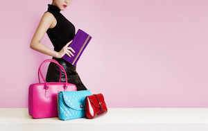 Woman with a  purse passing in front of the colorful bags. Fashion image with copy space.