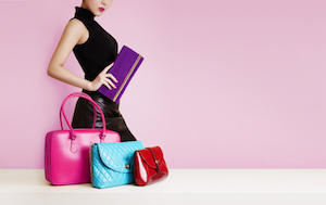 Woman with a purse passing in front of the colorful bags. Fashion image with copy space.